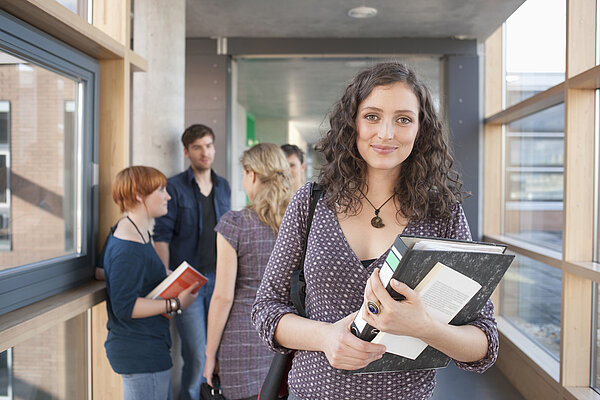Studentin in der Hochschule mit Unterlagen in der Hand